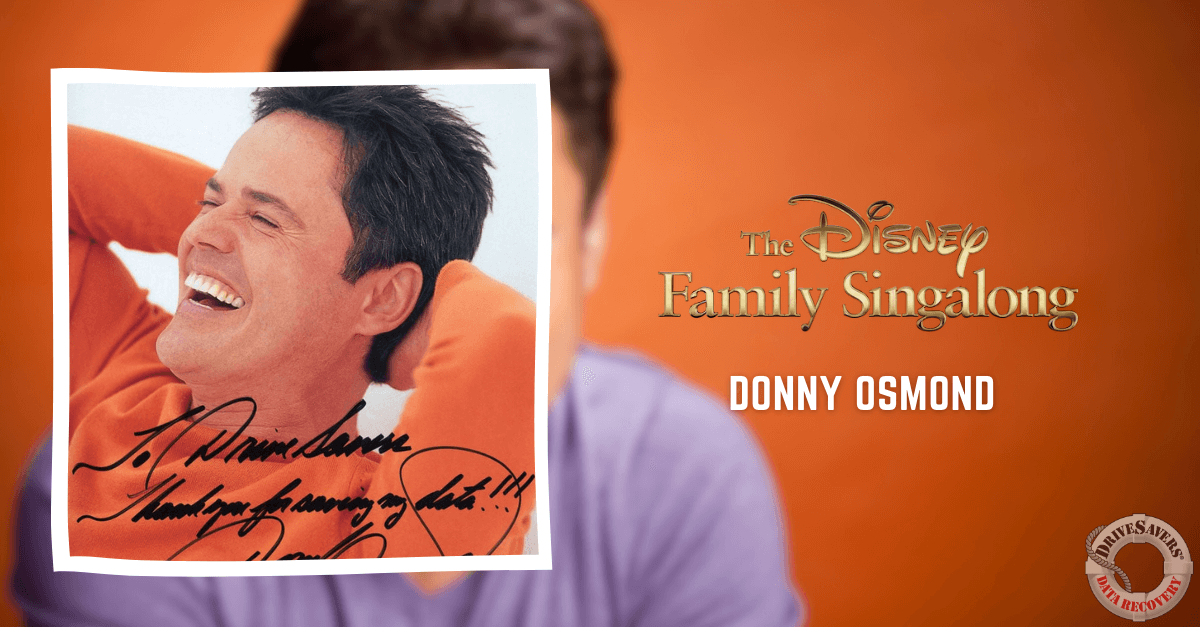 The promotional image for "The Disney Family Singalong" showcases a signed photograph of Donny Osmond. He is seen smiling and wearing an orange shirt. The background appears blurred, directing focus on Osmond's cheerful expression. A watermark can be spotted in the corner of the image.